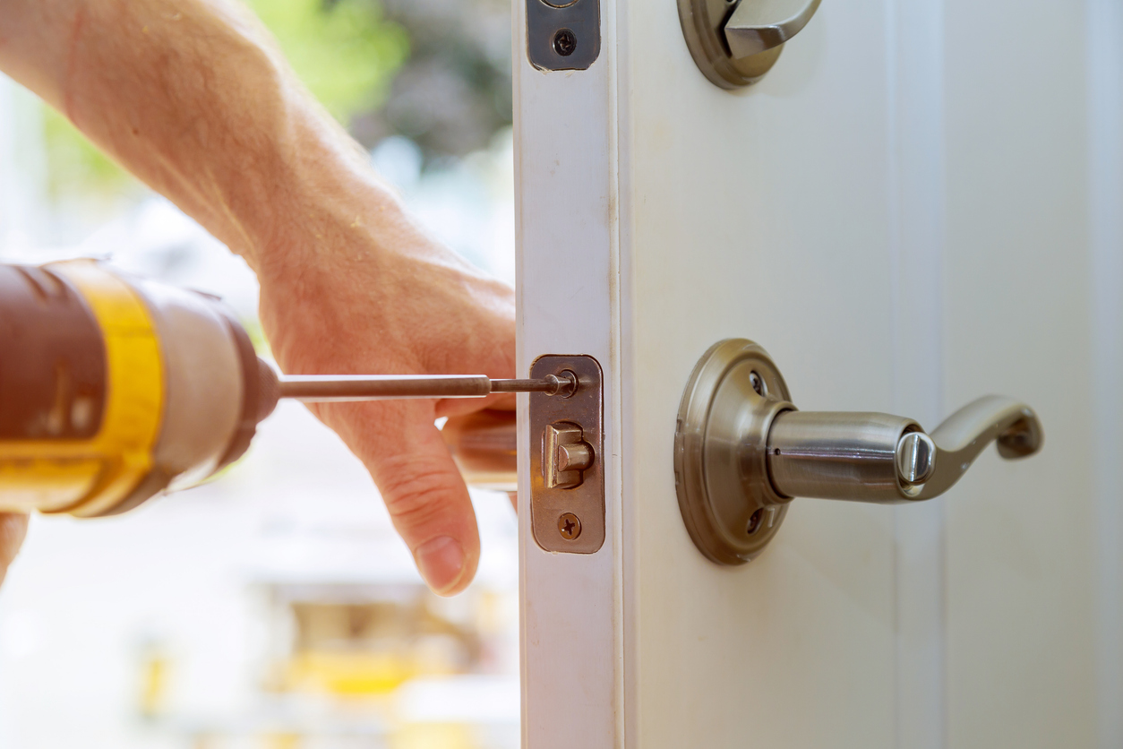 a professional installing a lock on an entry door replacement