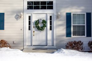 an secure and insulated entry door with a wreath on it in the winter