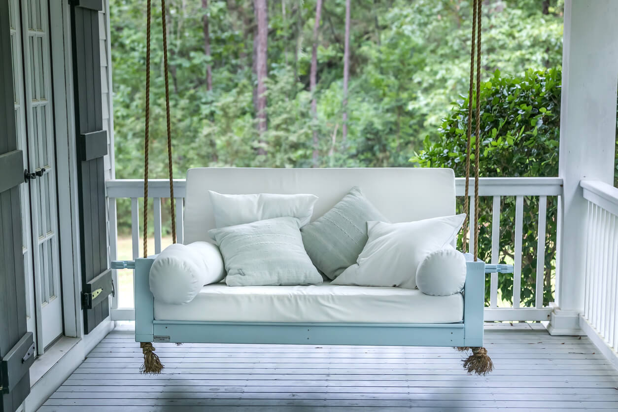 a hanging porch swing with throw pillows