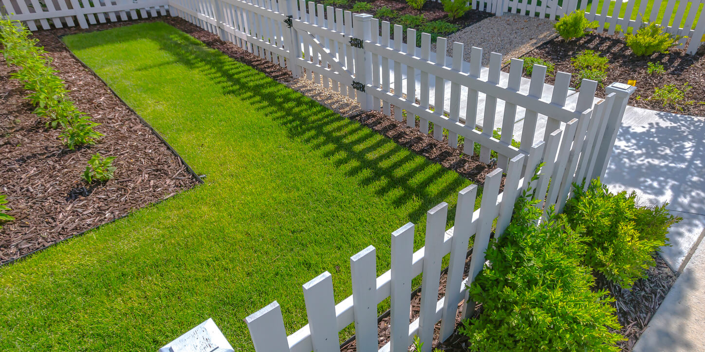 a white picket fence in a front yard