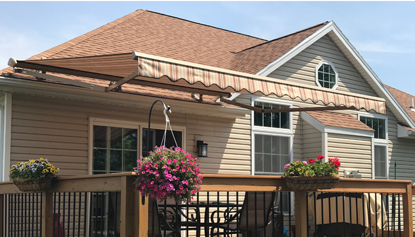 an awning on a deck with flowers on it