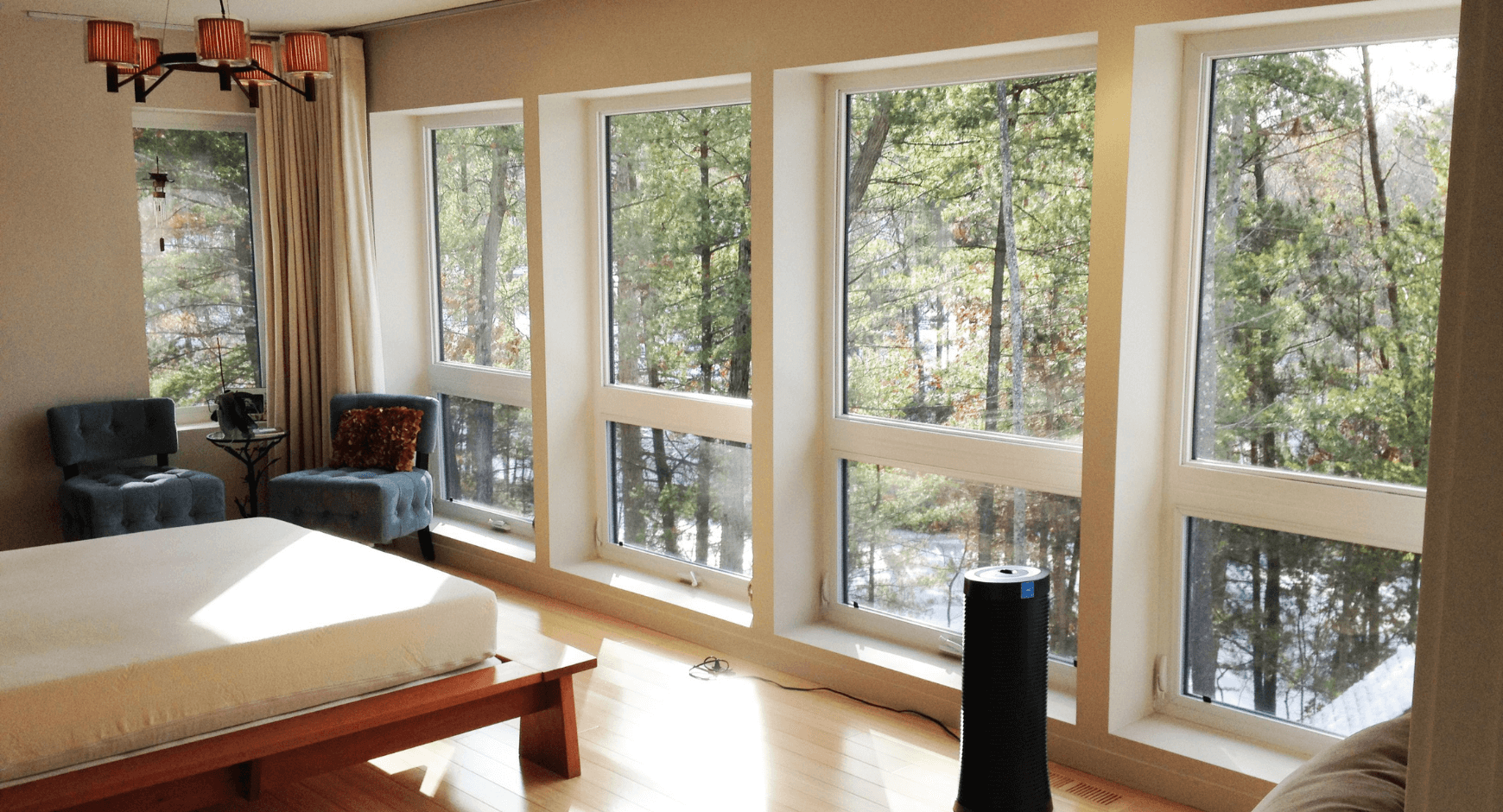 Image of a home with large windows looking out into the woods