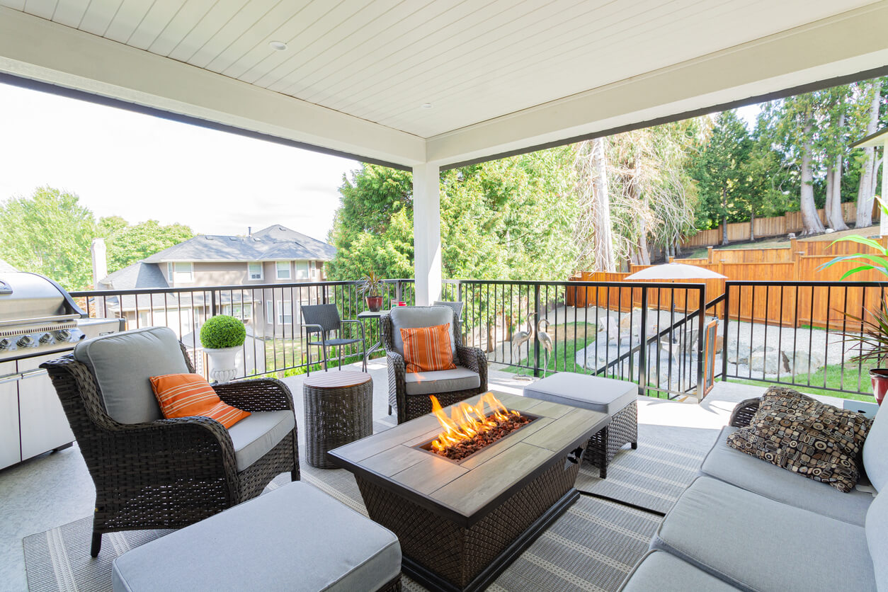 gas fire table on a deck with furniture around it