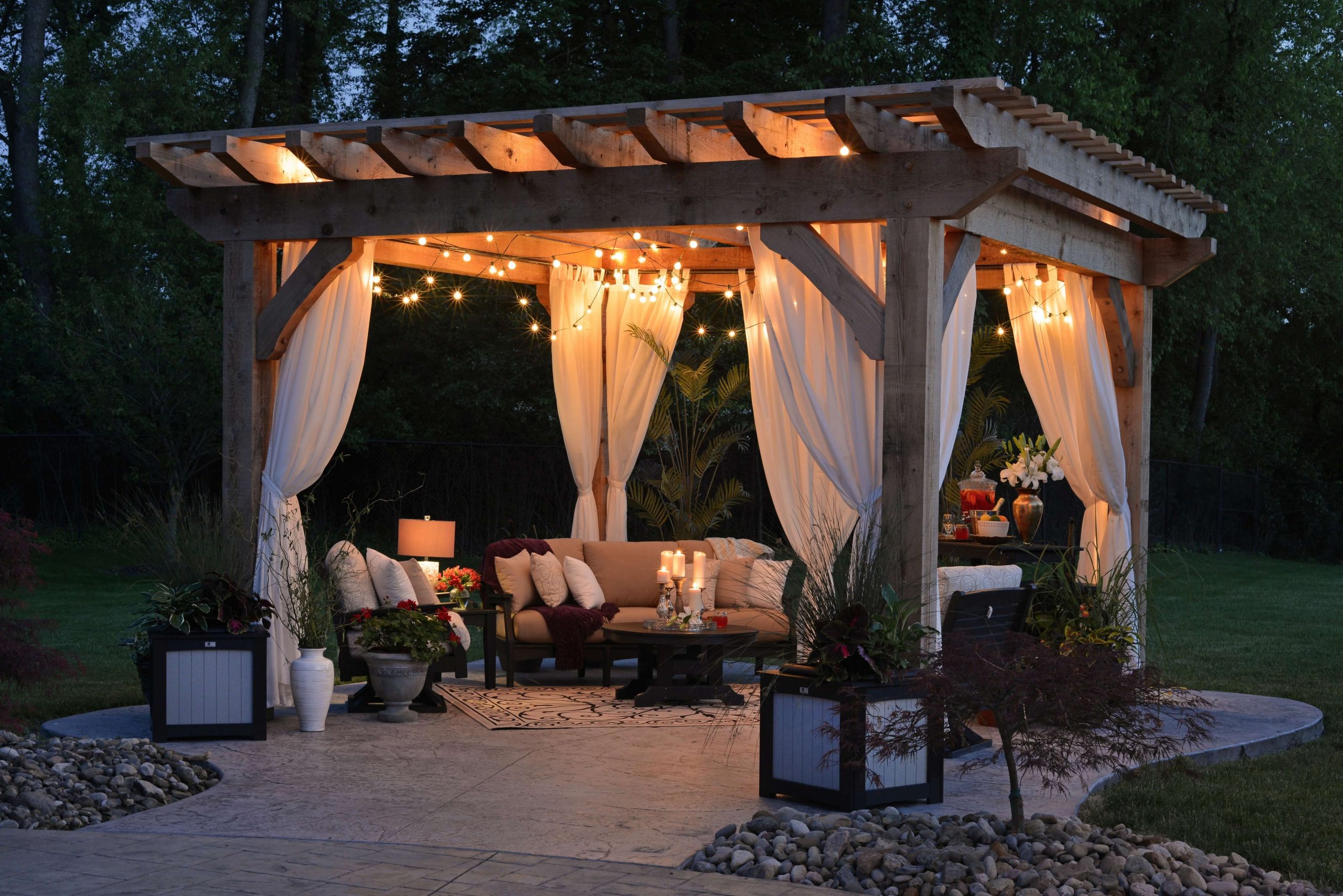 a patio with a pergola and string lights
