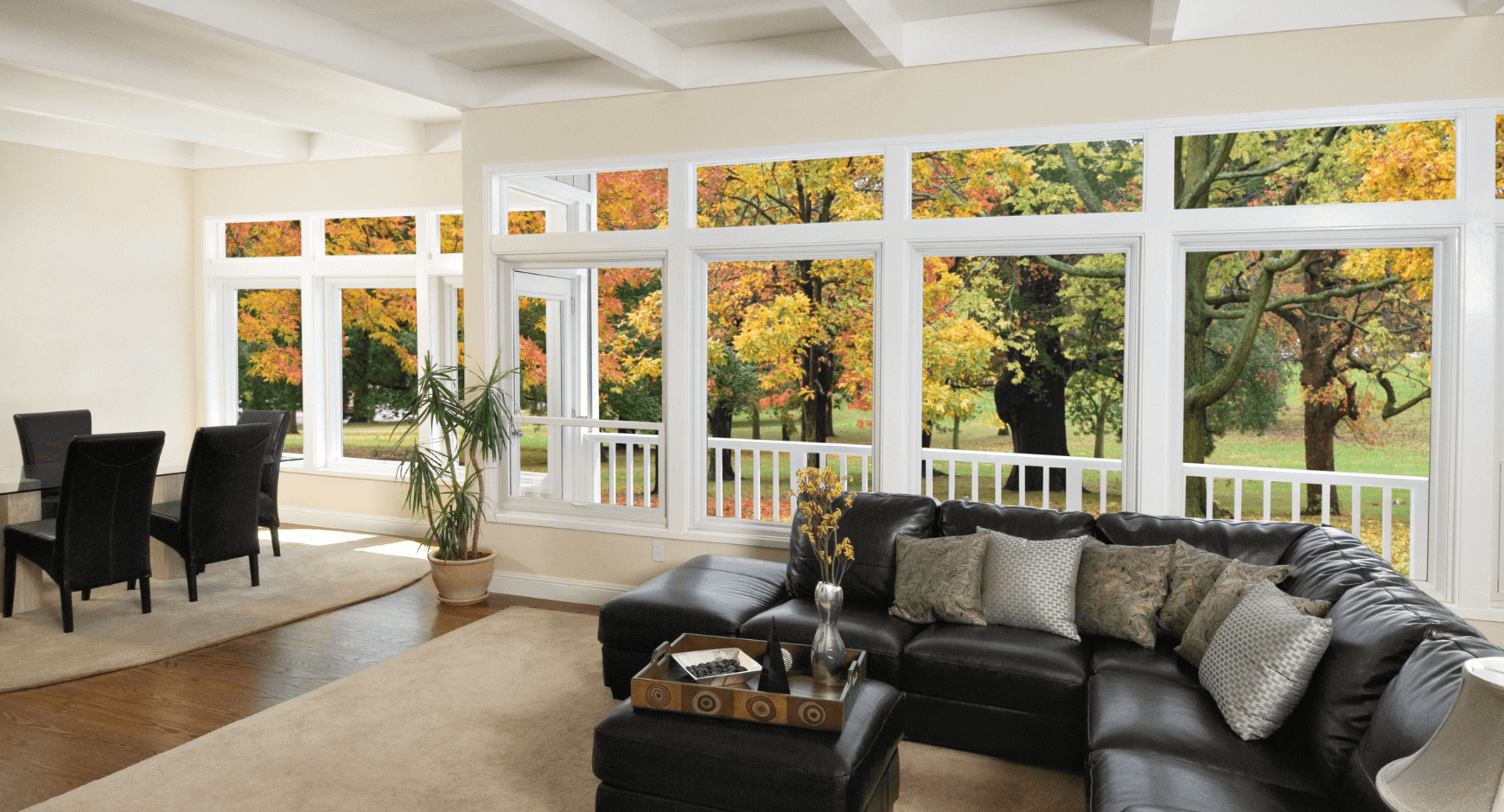 Image of a comfortable home with large windows looking out into the fall woods