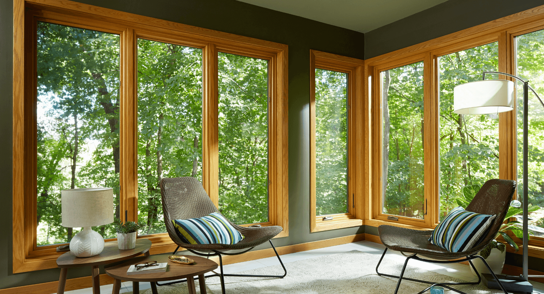 Image of an energy efficient home with large picture windows looking out into the woods