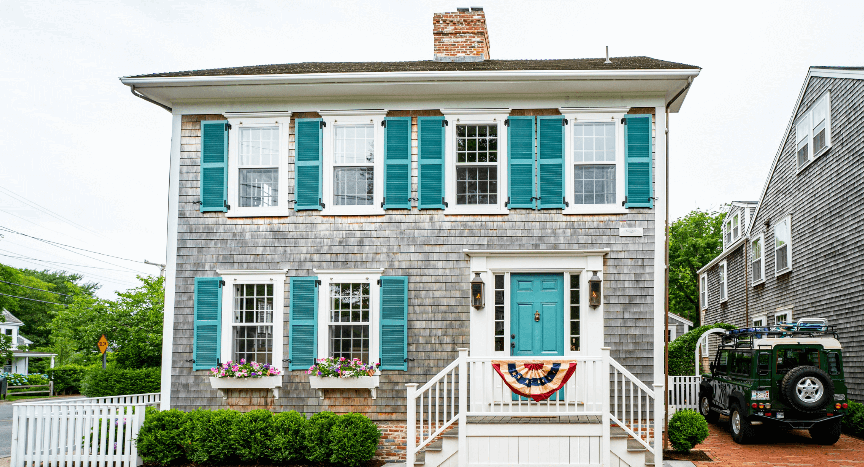 Image of a home with farmhouse window trim and blue shutters