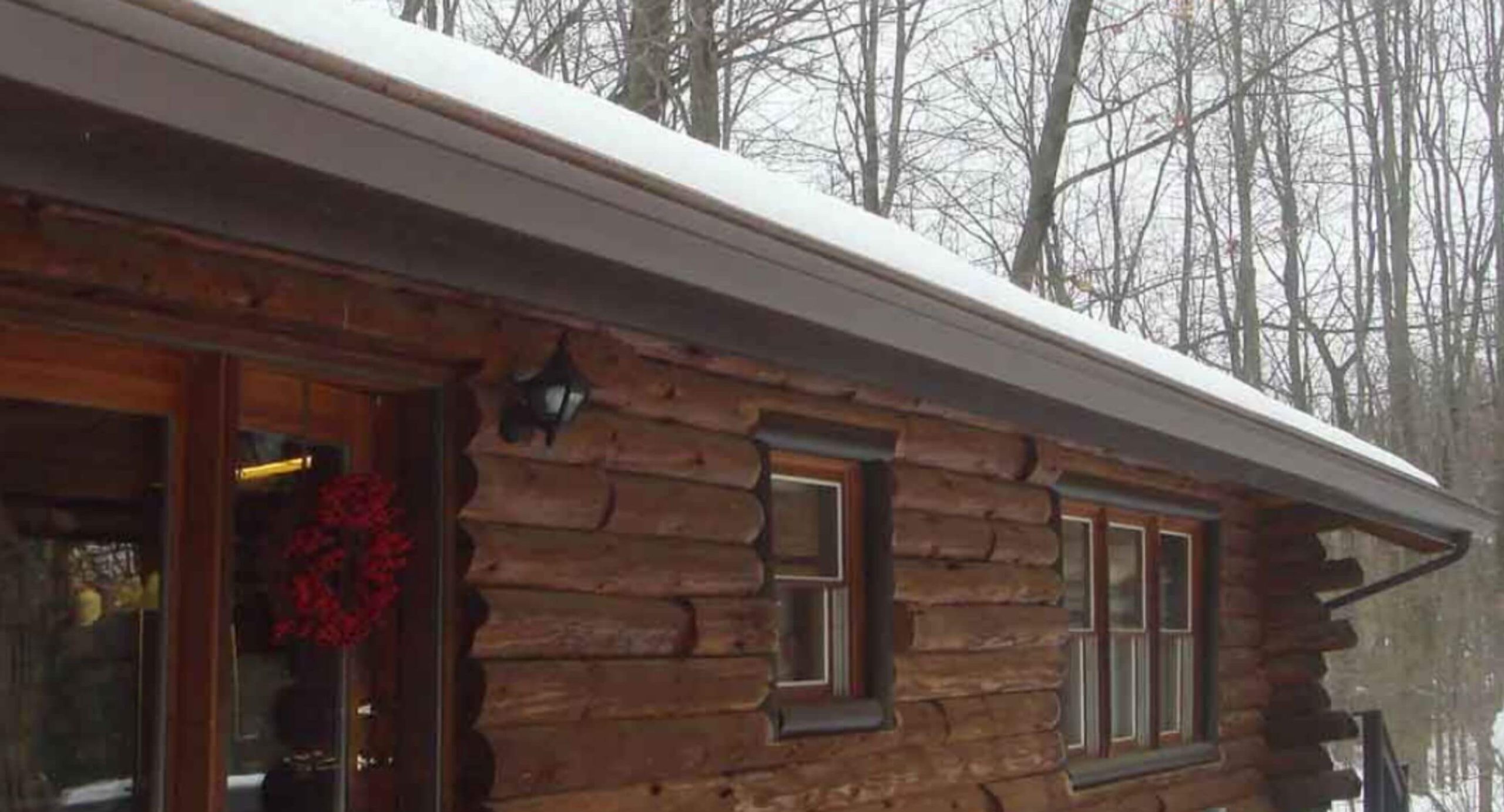 Clear gutters on a snowy cabin