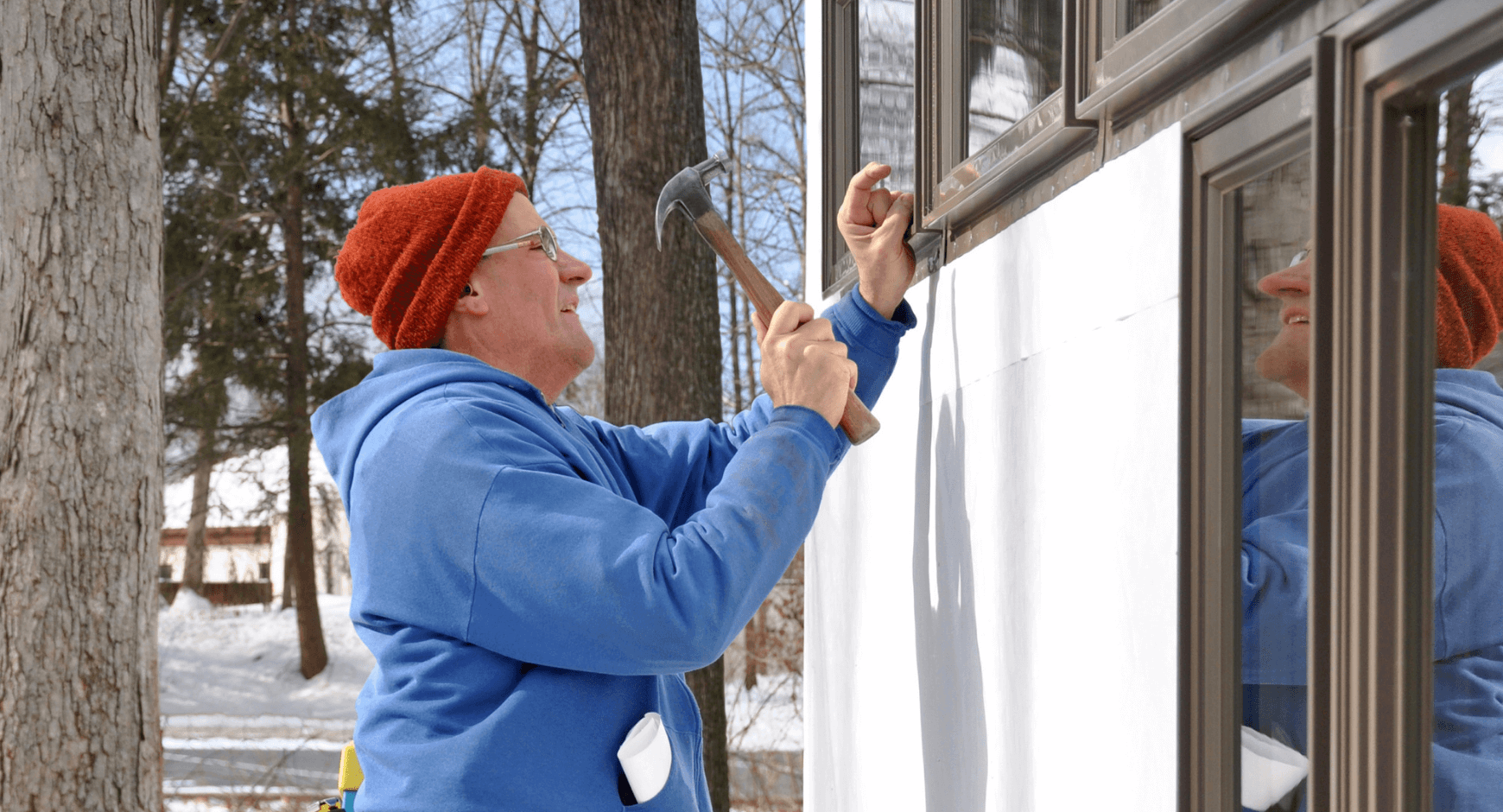 Image of a man replacing windows during the winter in the snow