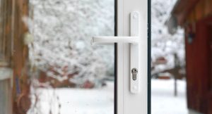 a storm door with a snowy backyard
