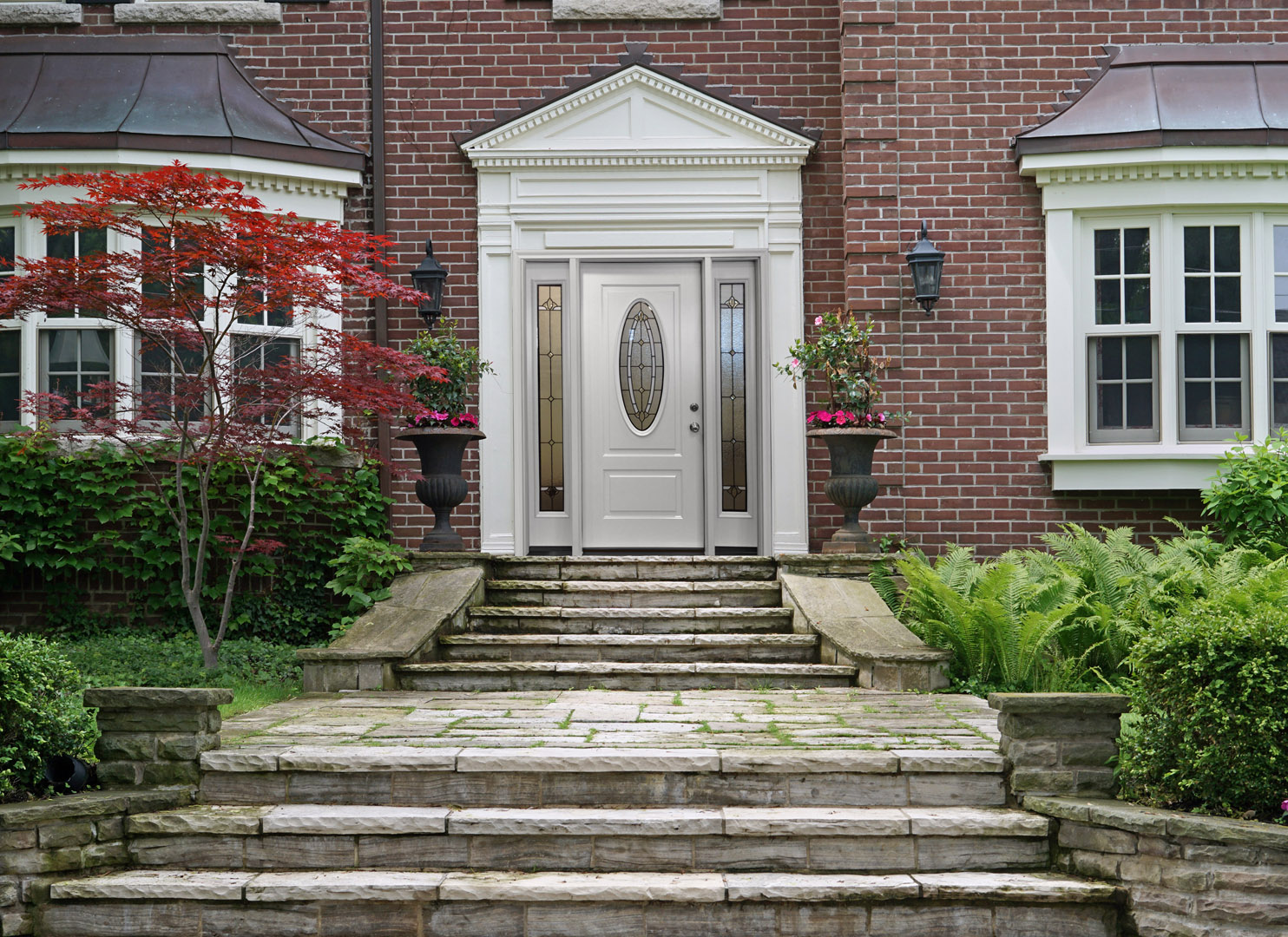 a white front entry door to a brick house