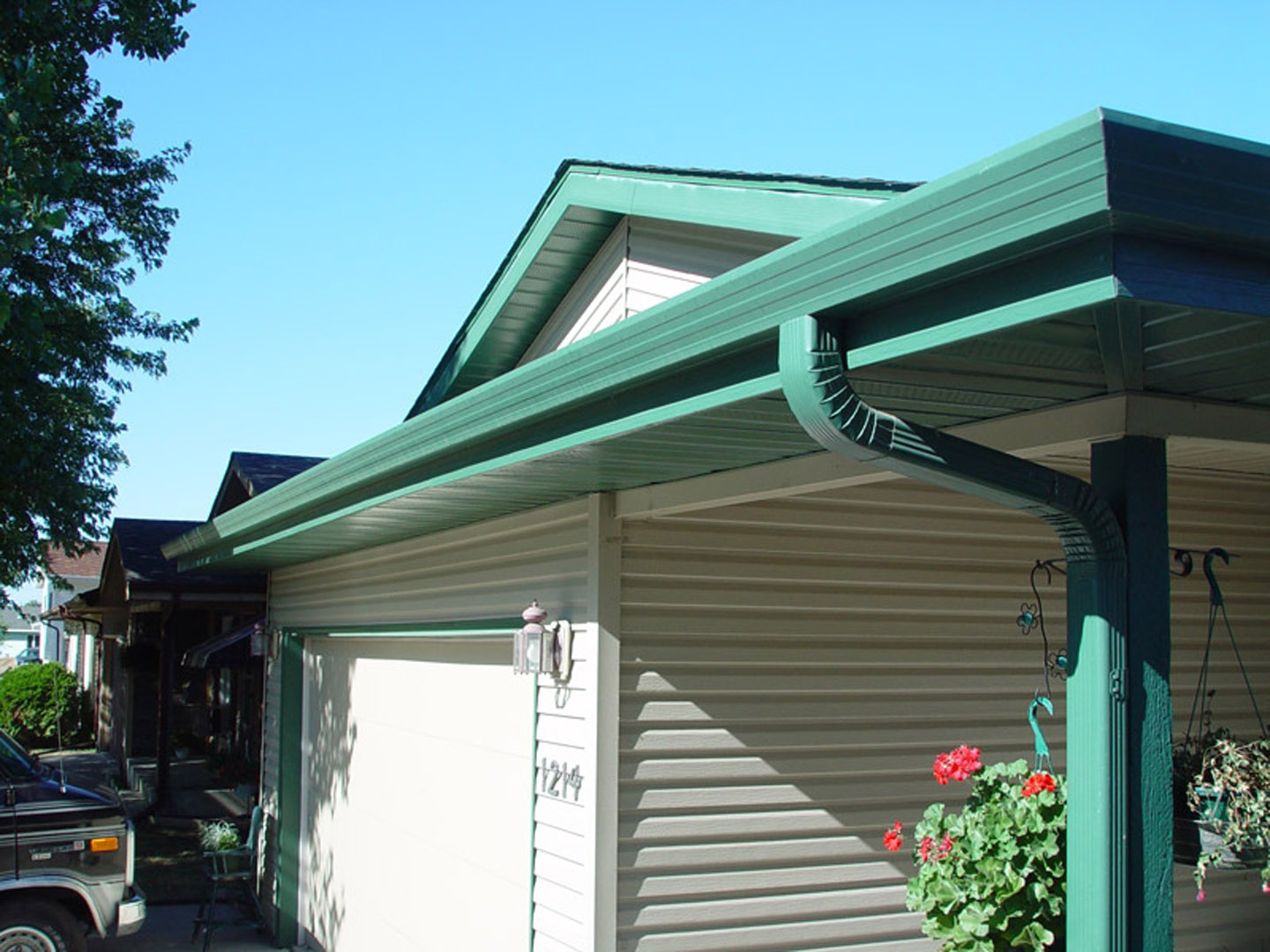 A white house with green seamless rain gutters