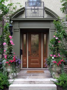 a front entry door with potted plants around it