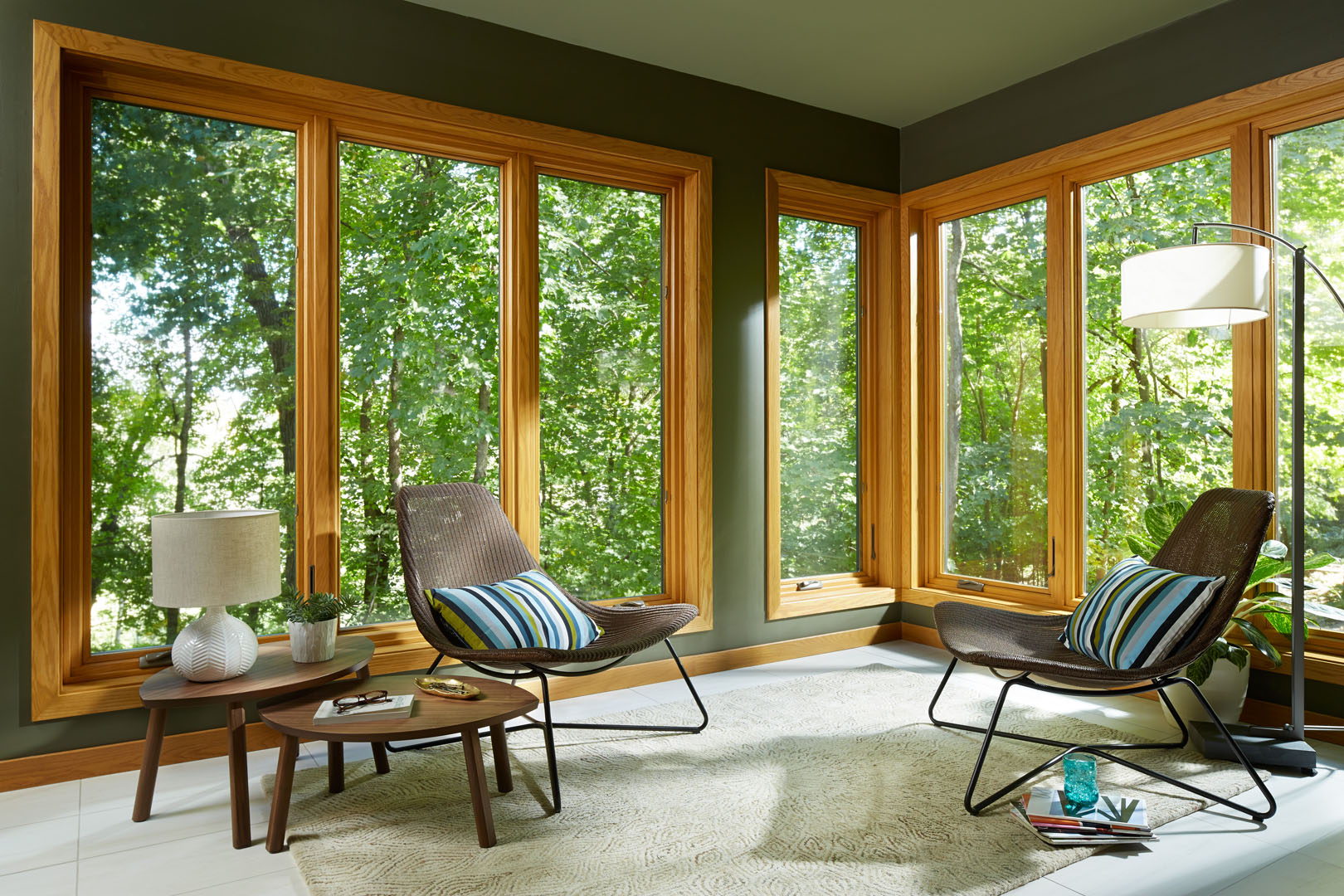 a living room with large windows and green trees outside