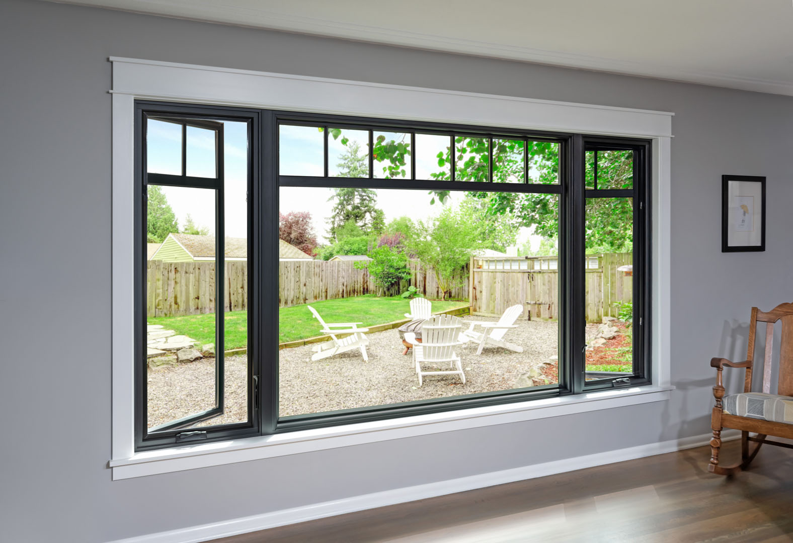 two open casement windows overlooking a backyard patio