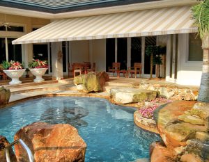 a sunesta awning over a backyard patio and pool