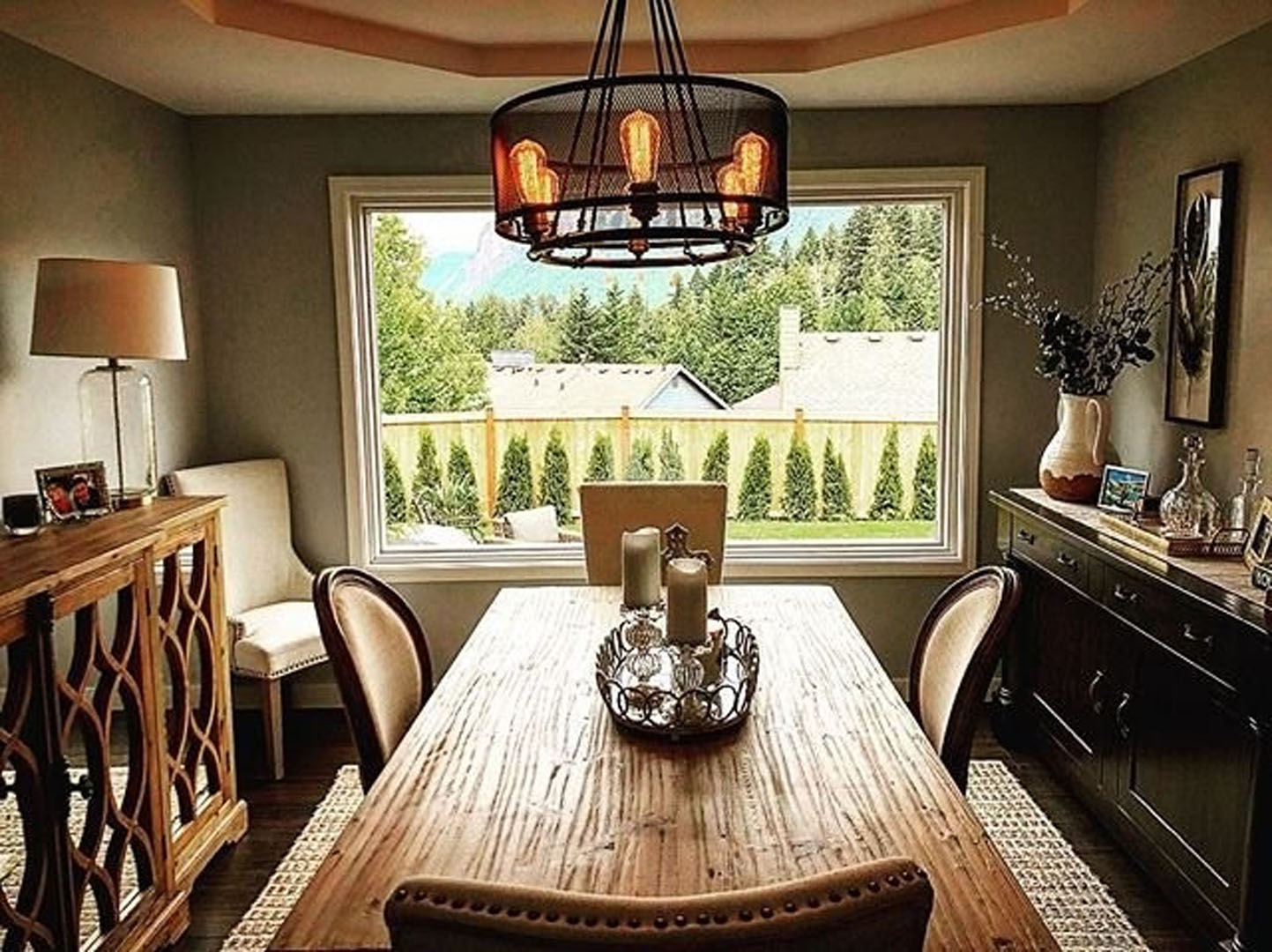 a picture window in a dining room looking out at a backyard