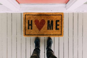 a welcome mat that says home with a heart instead of an o
