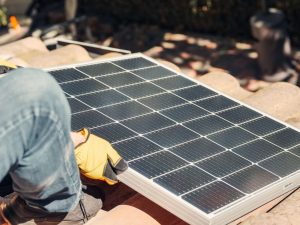 a contractor installing a solar panel on a house roof