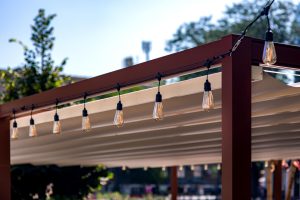 a pair of string lights on an outdoor pergola patio