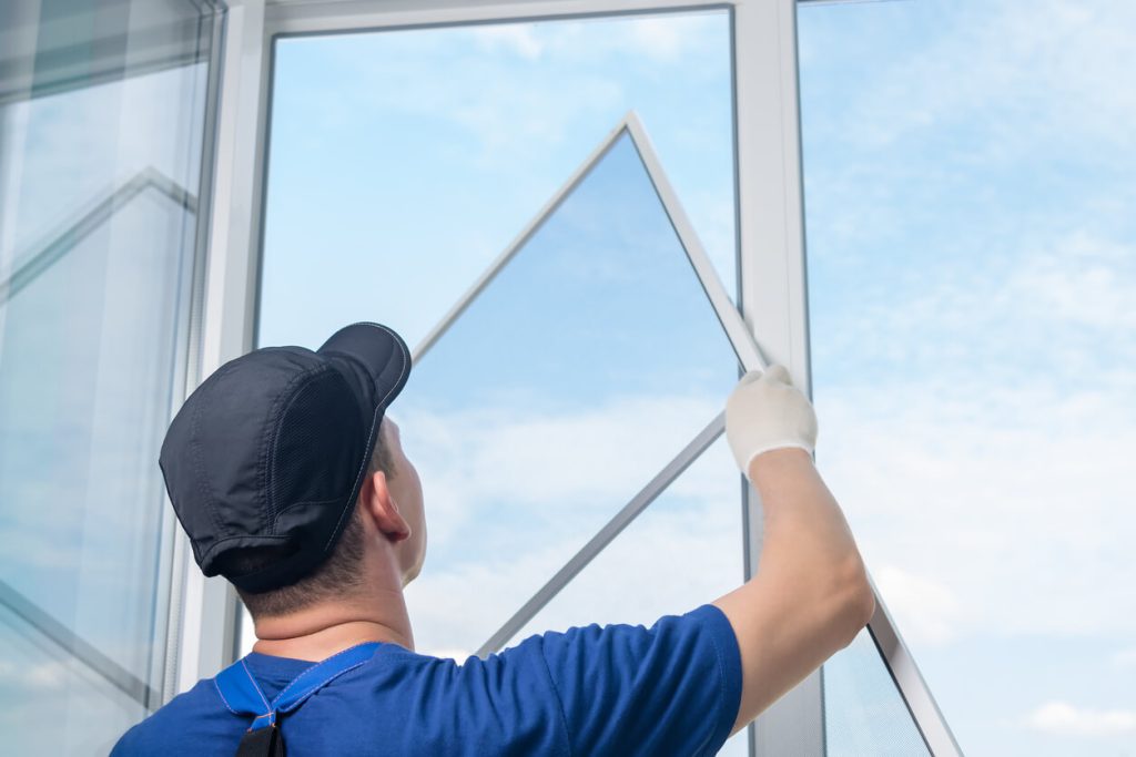 someone putting a window screen back in place