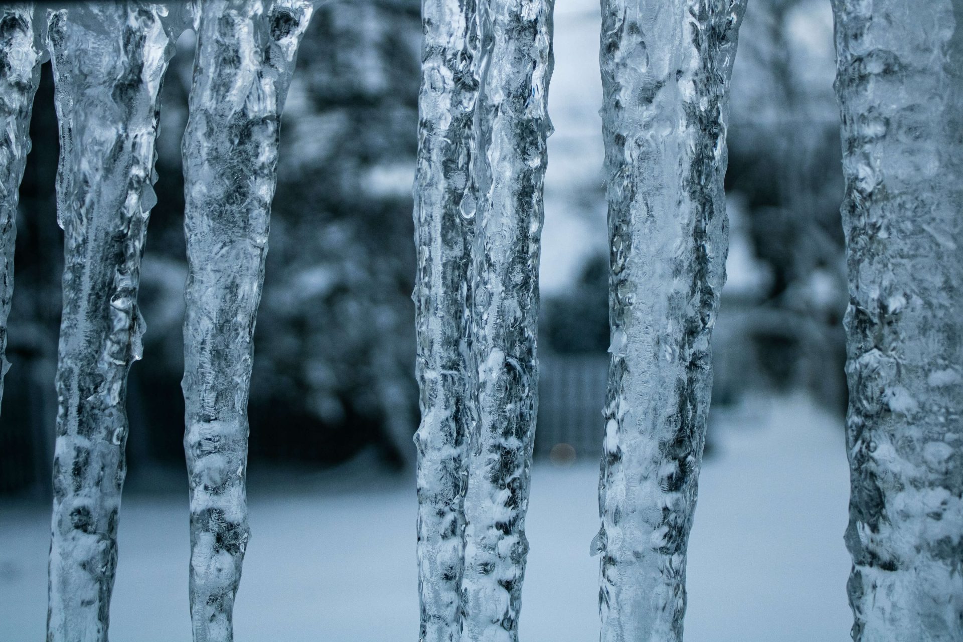 multiple icicles hanging from a home in the winter caused by ice or snow melting and refreezing